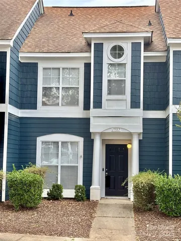 a front view of a house with plants