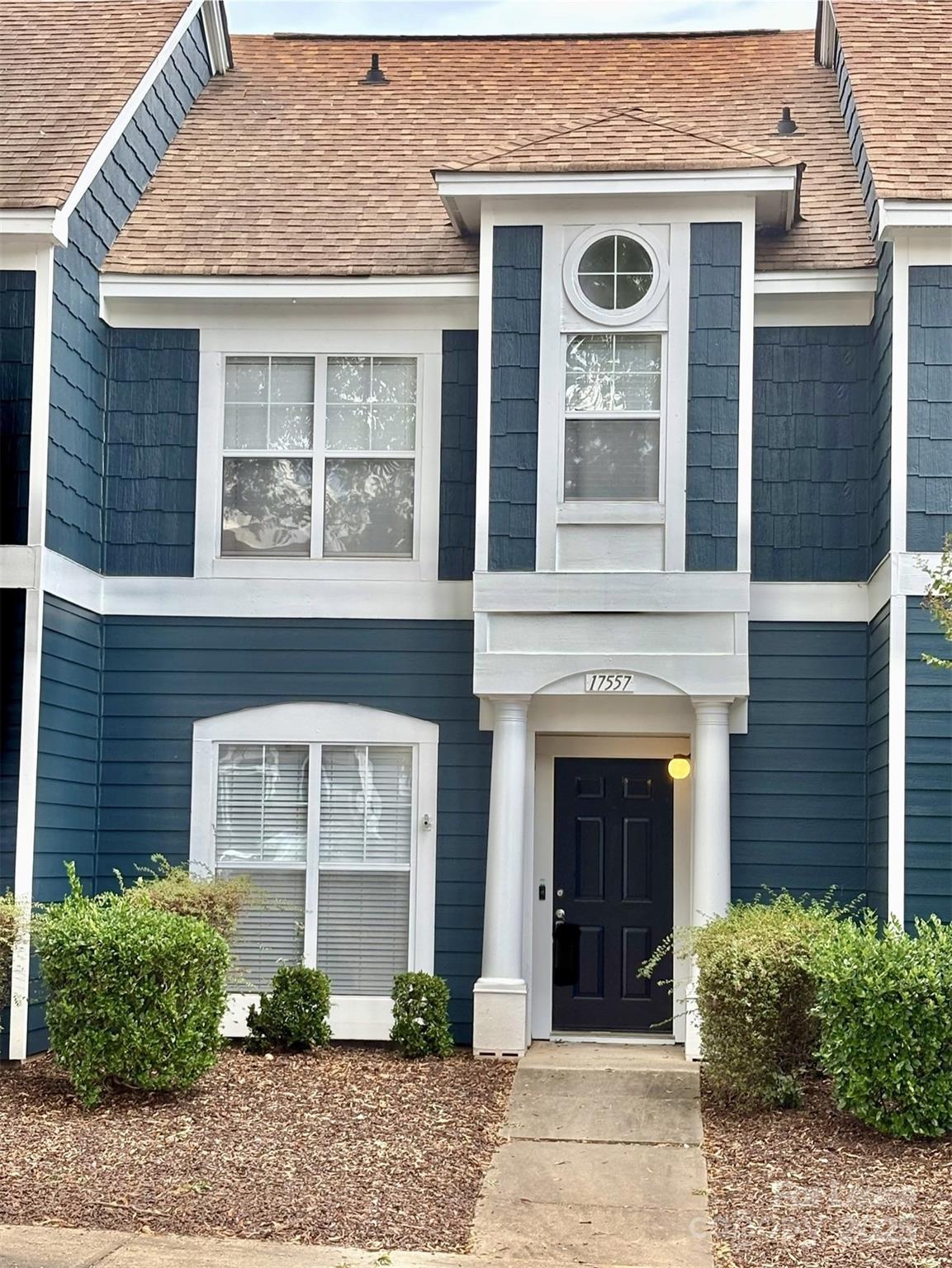 a front view of a house with plants