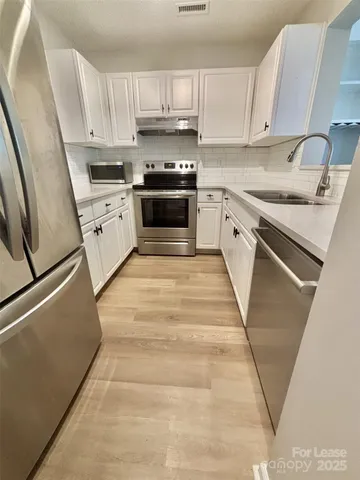 a kitchen with stainless steel appliances granite countertop a refrigerator stove and sink
