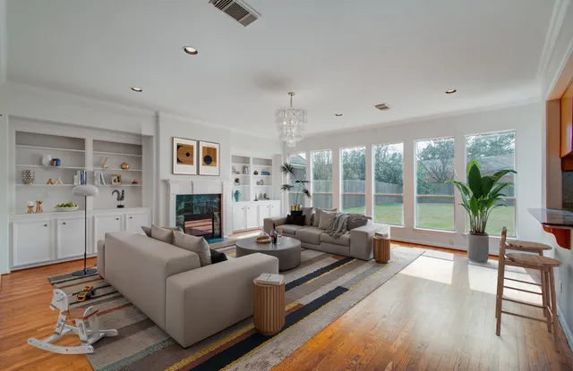 a living room with fireplace furniture and a large window