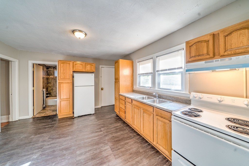 247-249 Commonwealth Avenue Springfield, MA 01108 - Photo 4 of 26 a large kitchen with stainless steel appliances a large window and a refrigerator