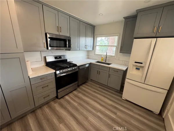 a kitchen with white cabinets and white appliances