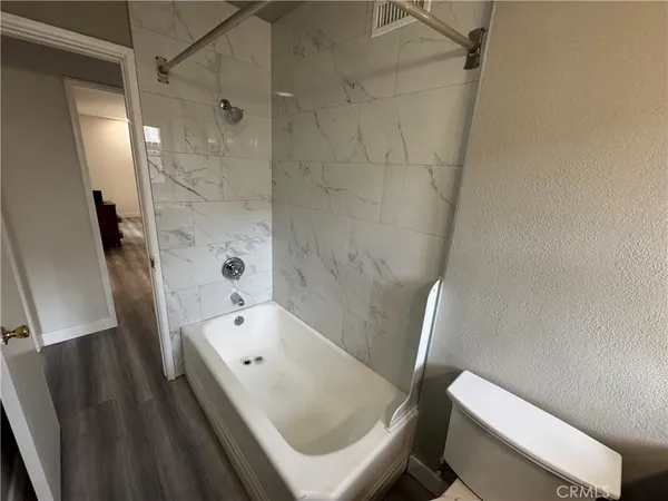 a bathroom with a bathtub shower and toilet
