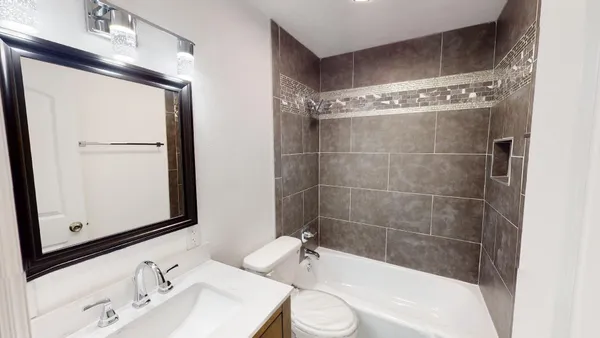 a bathroom with a bathtub shower sink and a toilet