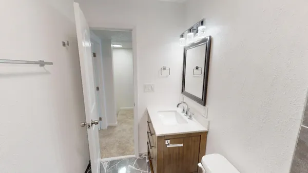 a bathroom with a toilet a sink and mirror