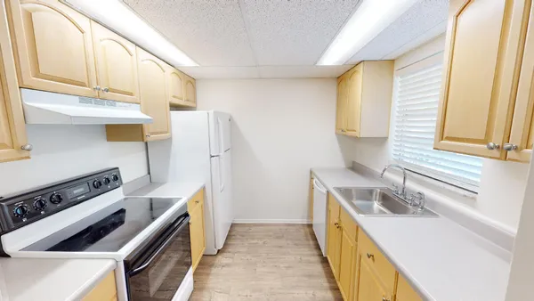 a kitchen with stainless steel appliances a stove a sink and a refrigerator