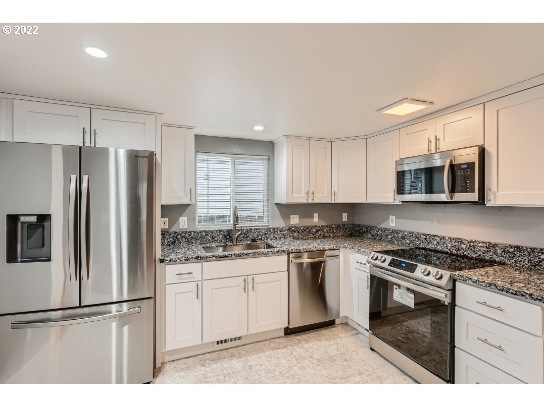 12603 Southeast Foster Road Portland, OR 97236 - Photo 12 of 28 a kitchen with stainless steel appliances granite countertop a stove a refrigerator and a microwave