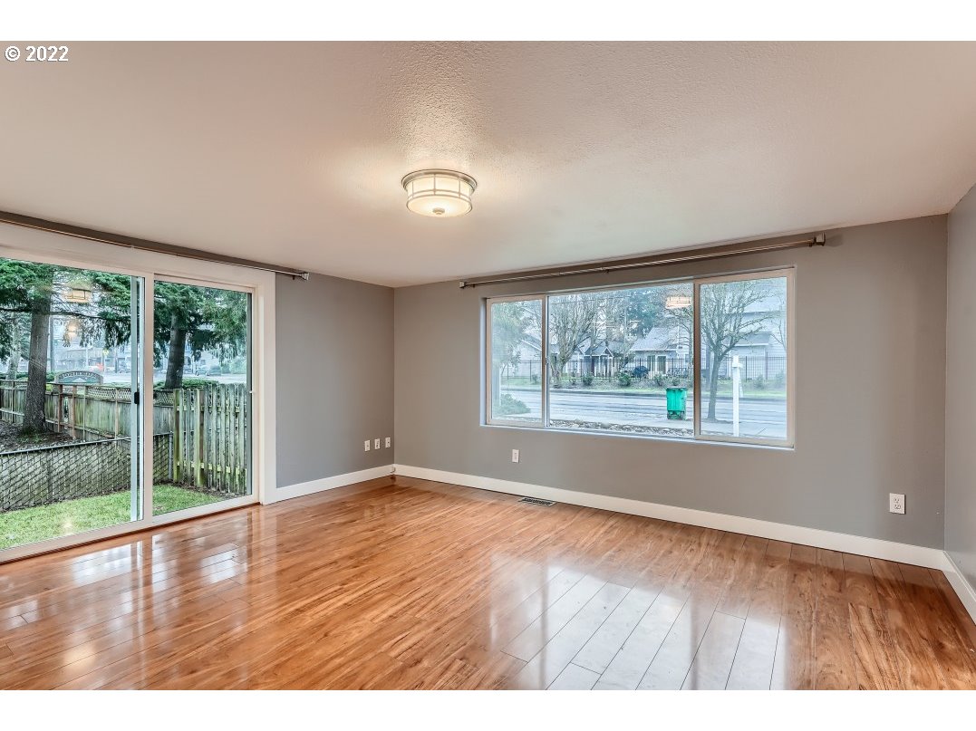12603 Southeast Foster Road Portland, OR 97236 - Photo 9 of 28 an empty room with wooden floor and windows