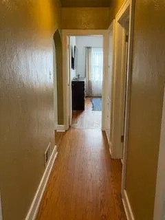 a view of a hallway with wooden floor