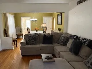 a living room with furniture and a large mirror next to a window