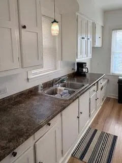 a kitchen with granite countertop a sink and white cabinets