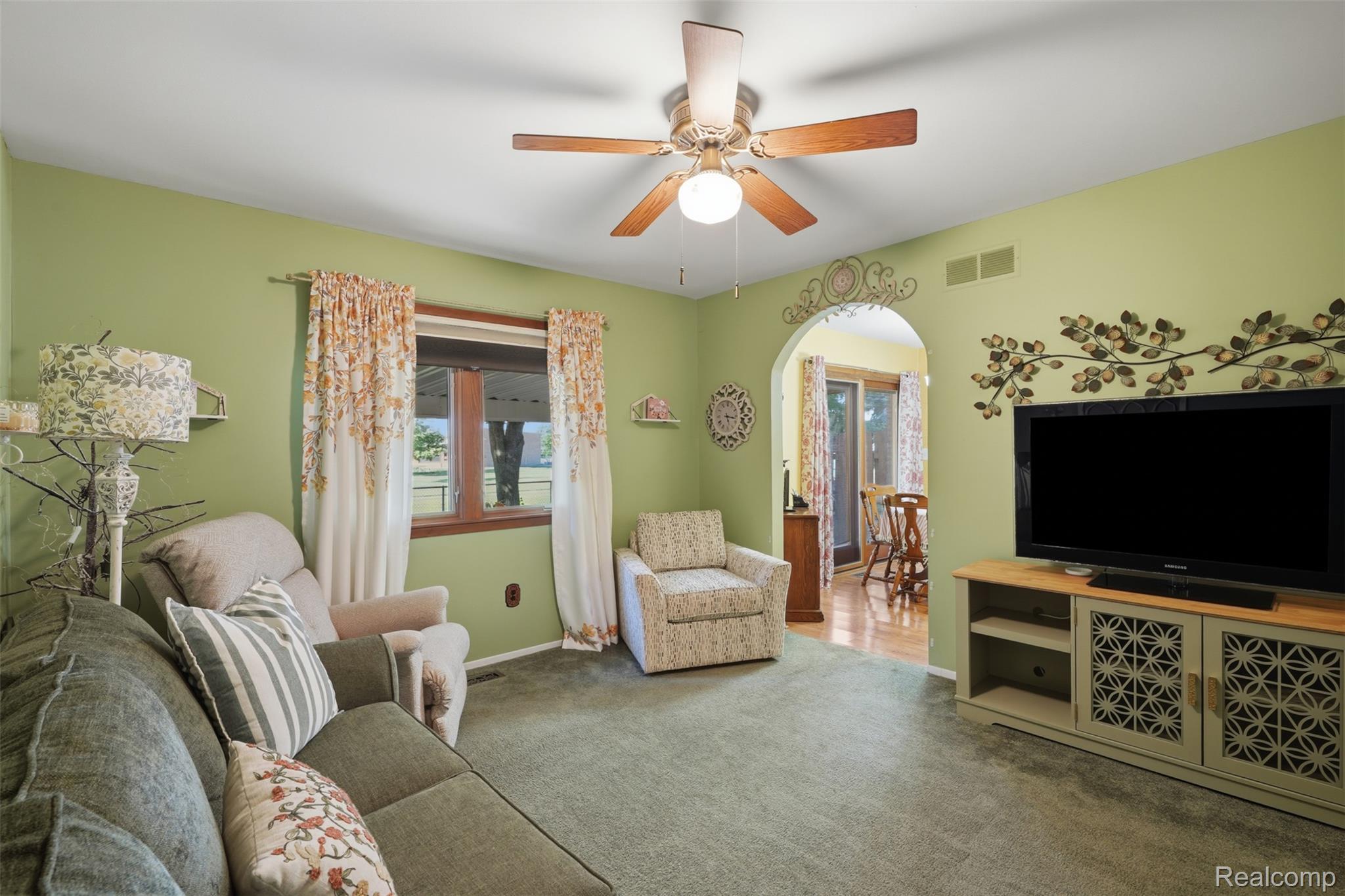 18160 Raleigh Square Drive Southgate, MI 48195 - Photo 11 of 31 Living area featuring a ceiling fan with light fixture, an arched doorway, and soft green wall paint