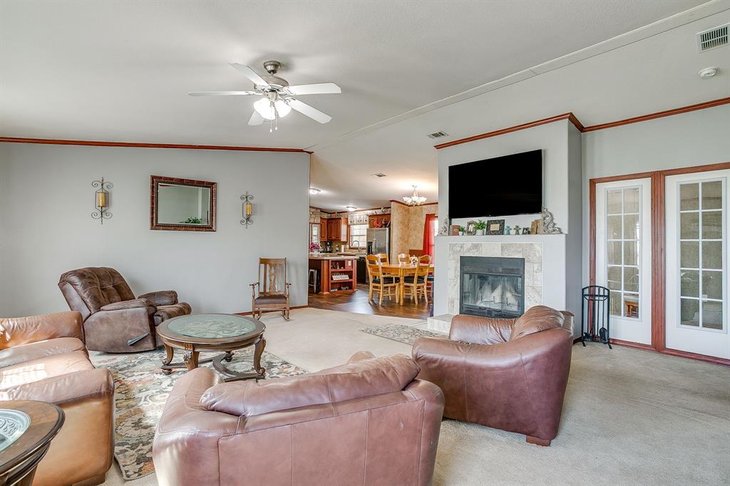 321 Young Road Millsap, TX 76066 - Photo 6 of 28 a living room with furniture a fireplace and a flat screen tv