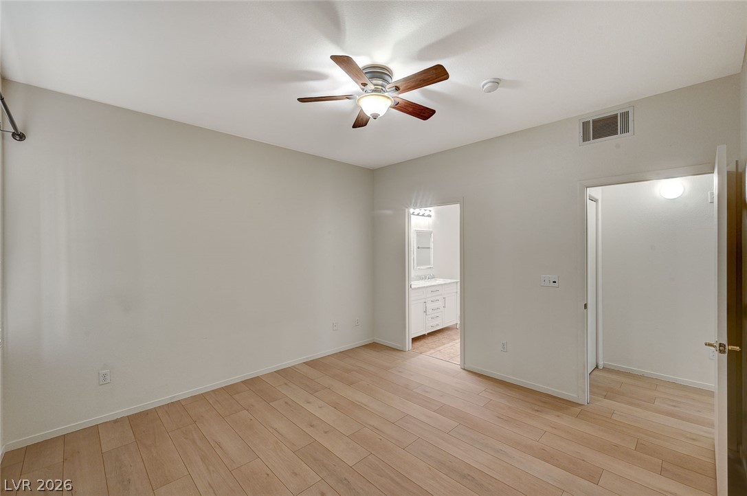 9050 West Warm Springs Road, Unit 1147 Las Vegas, NV 89148 - Photo 25 of 36 Bright hardwood floors and a ceiling fan create a comfortable atmosphere in this inviting bedroom.