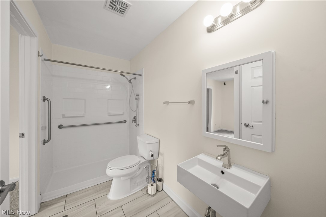 3796 North Santom Road Stow, OH 44224 - Photo 14 of 30 Modern bathroom featuring a white floating vanity with a rectangular sink and brushed nickel faucet