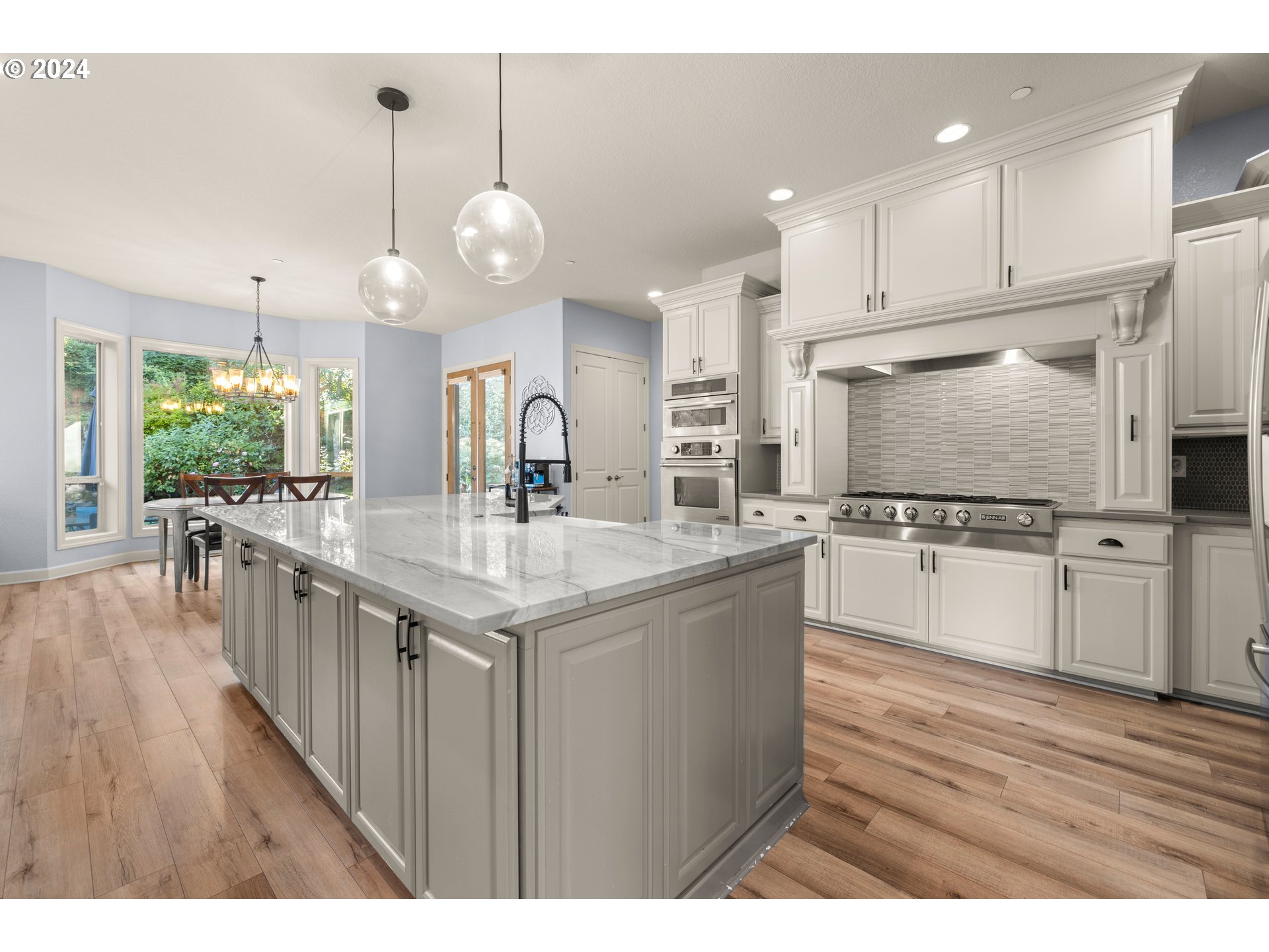 606 Northwest 24th Circle Camas, WA 98607 - Photo 15 of 48 a kitchen with stainless steel appliances kitchen island granite countertop a stove a sink and a wooden floors