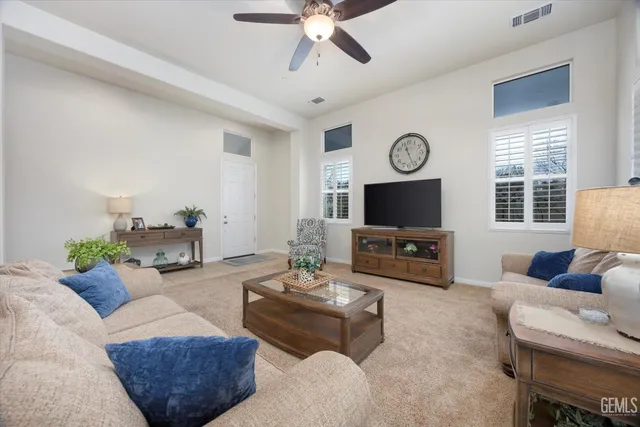 a living room with furniture a flat screen tv and a large window