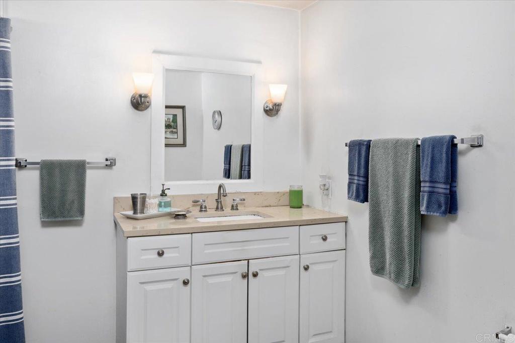 4660 North River Road, Unit 150 Oceanside, CA 92057 - Photo 13 of 23 a bathroom with a double vanity sink and mirror