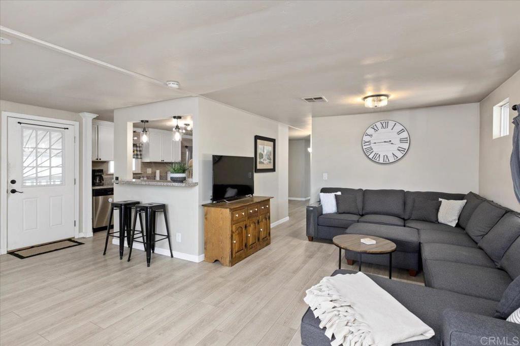 4660 North River Road, Unit 150 Oceanside, CA 92057 - Photo 2 of 23 a living room with furniture and a flat screen tv