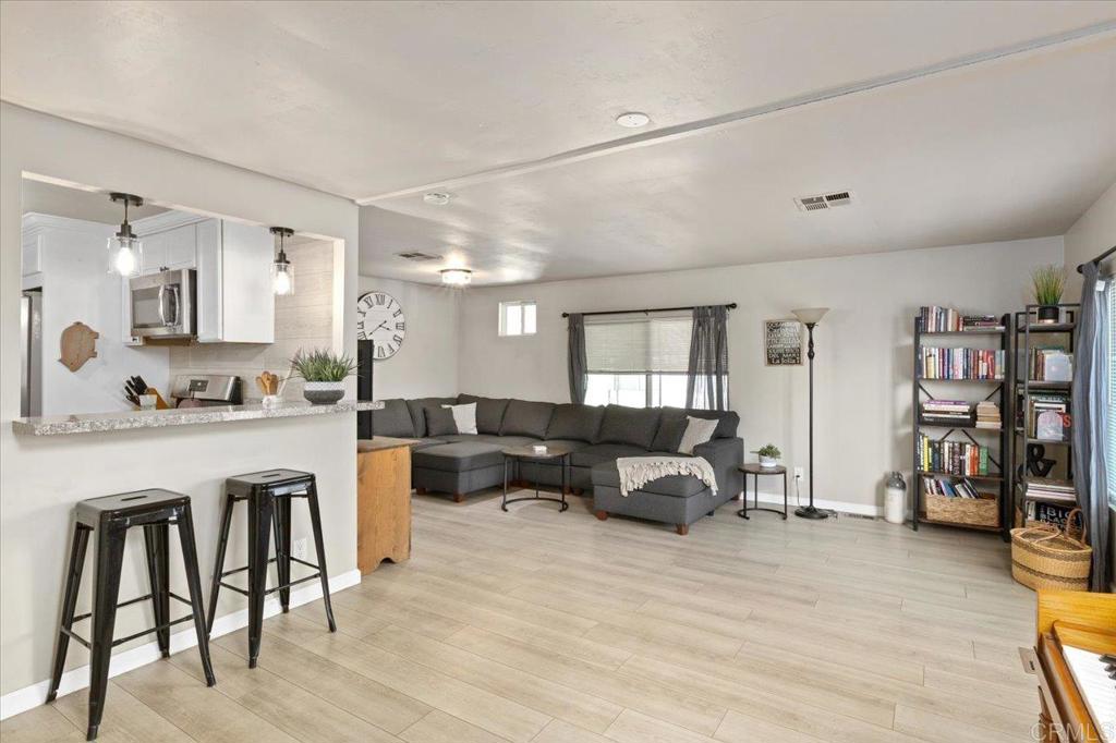 4660 North River Road, Unit 150 Oceanside, CA 92057 - Photo 4 of 23 a living room with furniture and a wooden floor