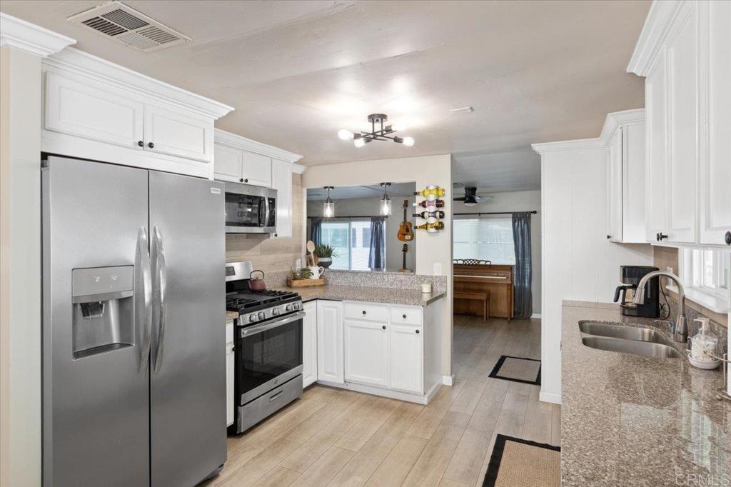 4660 North River Road, Unit 150 Oceanside, CA 92057 - Photo 6 of 23 a kitchen with cabinets and stainless steel appliances