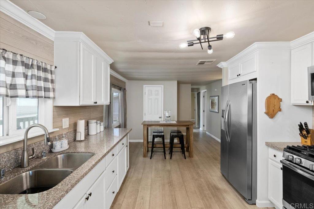 4660 North River Road, Unit 150 Oceanside, CA 92057 - Photo 7 of 23 a kitchen with granite countertop a sink stainless steel appliances and cabinets