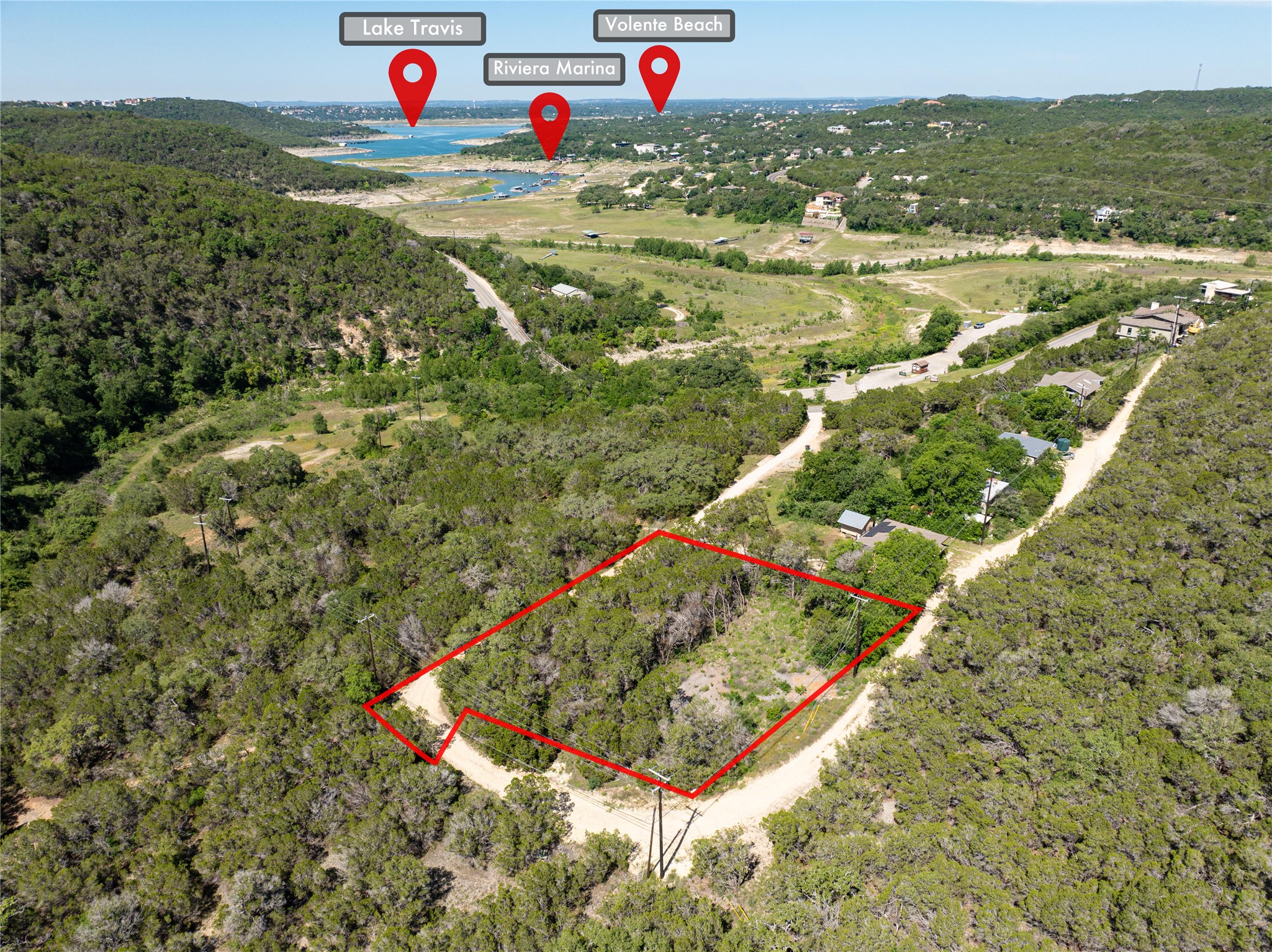 Aerial view of property and surrounding area featuring property boundaries highlighted and a large body of water