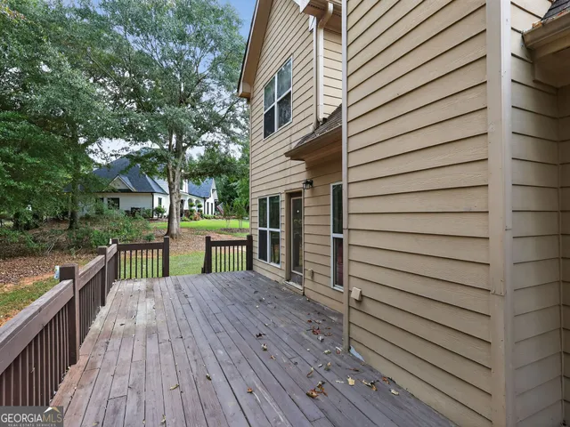 a view of a deck with wooden floor and fence next to a yard