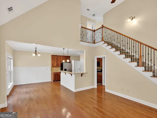 a view of a hallway with wooden floor and kitchen