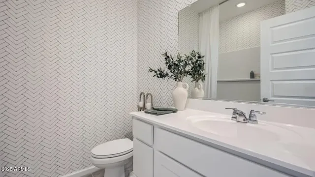 a bathroom with a granite countertop sink and a toilet