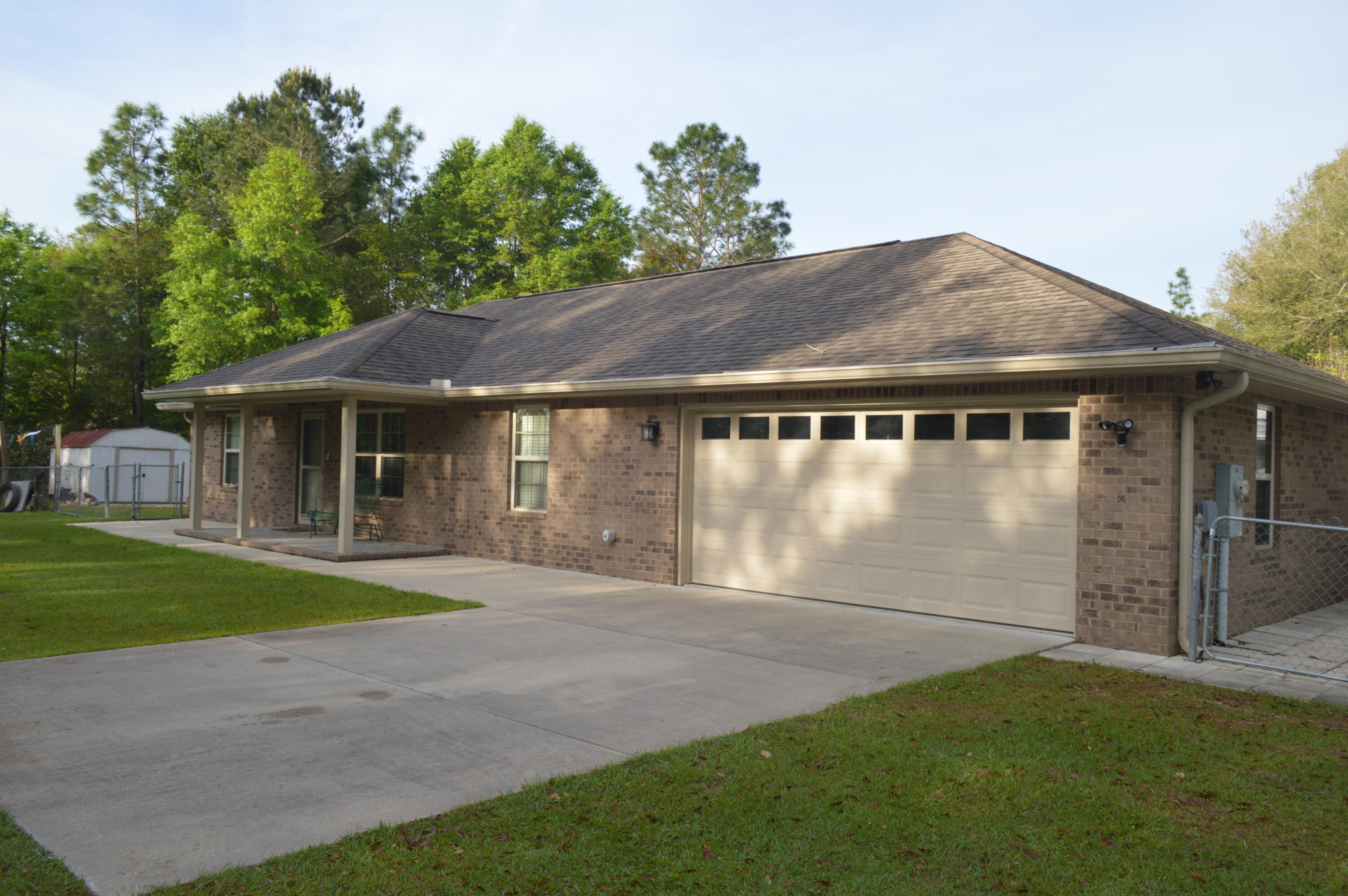 3939 Painter Branch Road Crestview, FL 32539 - Photo 2 of 35 a front view of a house with a garden and yard