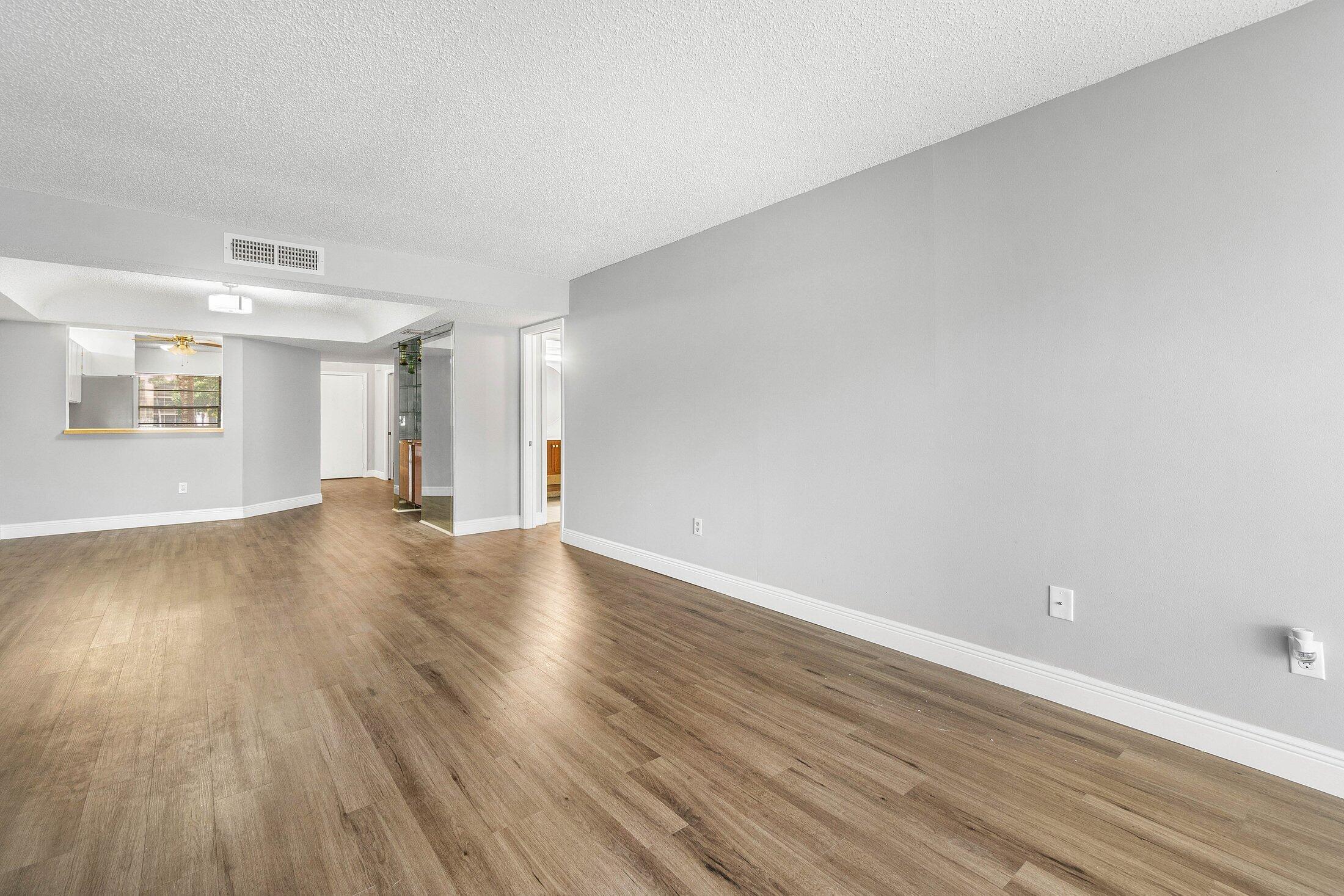 23395 Carolwood Lane, Unit 207 Boca Raton, FL 33428 - Photo 13 of 39 a view of a room with wooden floor and window