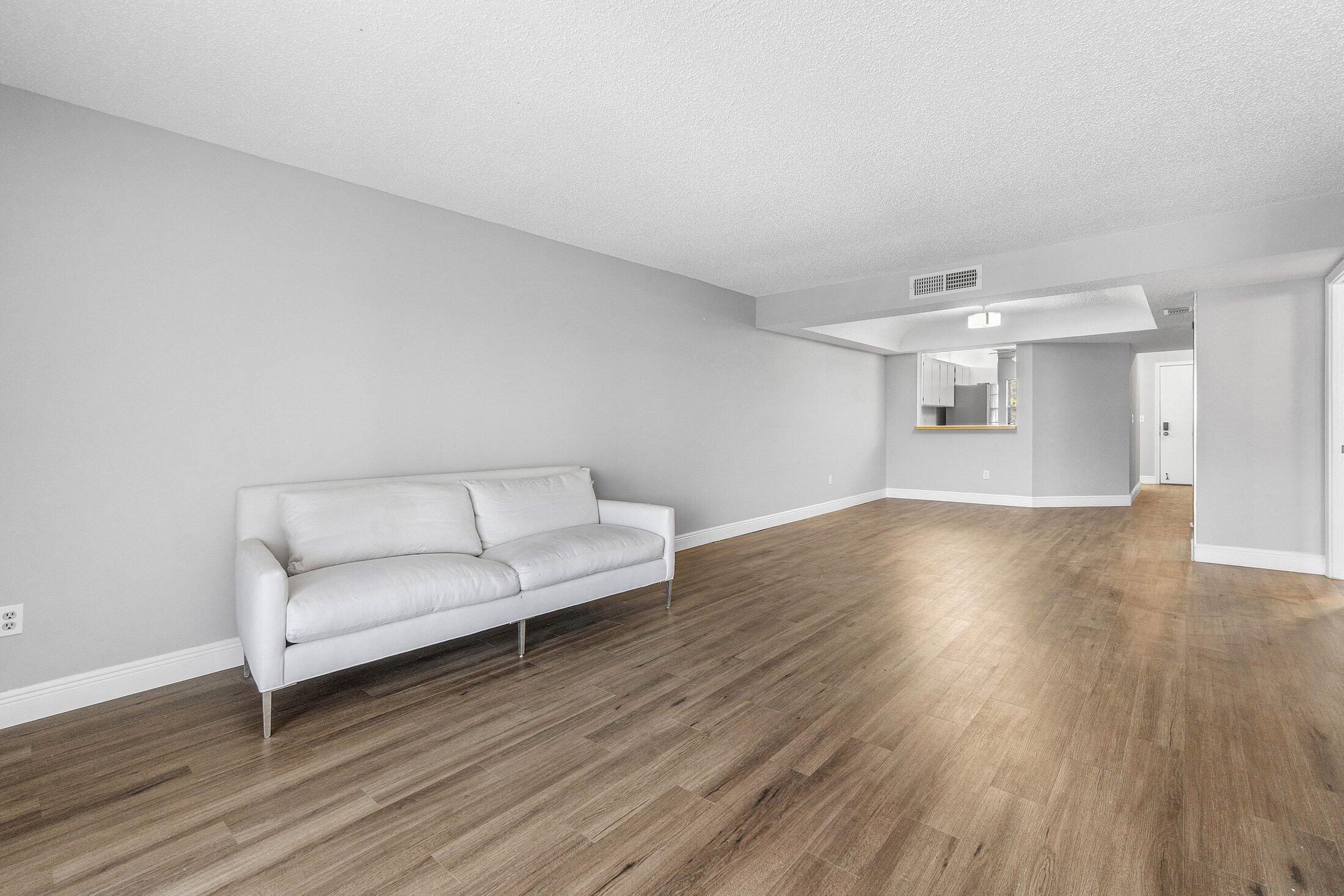 23395 Carolwood Lane, Unit 207 Boca Raton, FL 33428 - Photo 15 of 39 a living room with furniture and a wooden floor