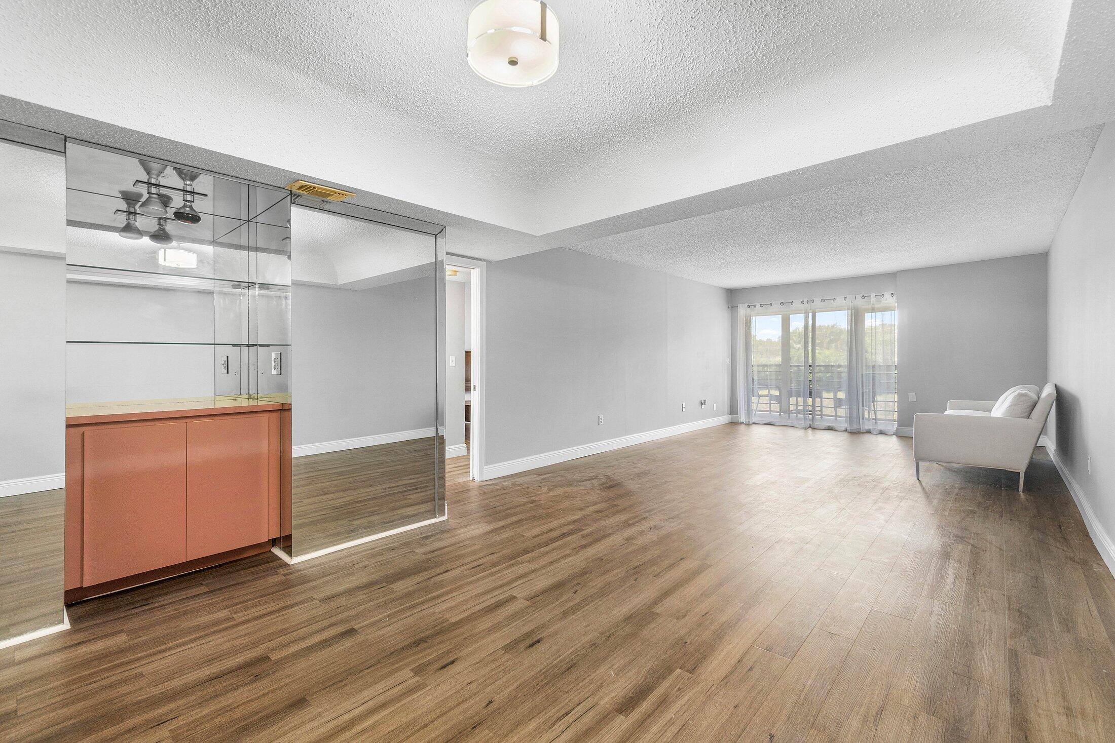 23395 Carolwood Lane, Unit 207 Boca Raton, FL 33428 - Photo 17 of 39 a view of empty room with wooden floor