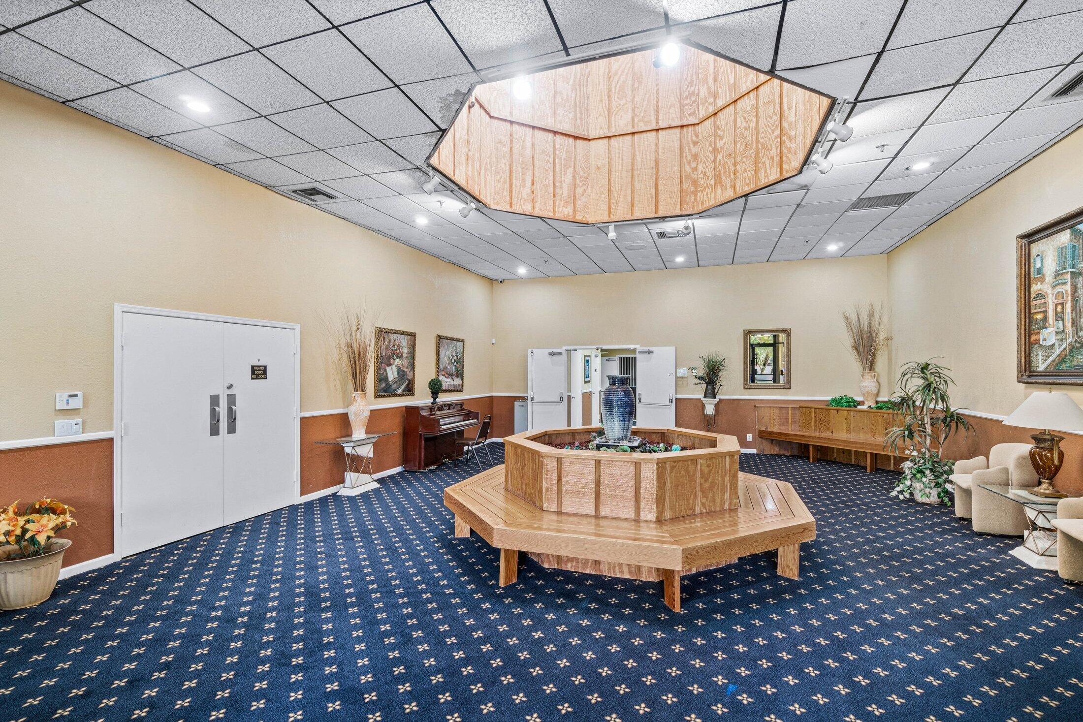 23395 Carolwood Lane, Unit 207 Boca Raton, FL 33428 - Photo 33 of 39 a living room with furniture a table and a chandelier