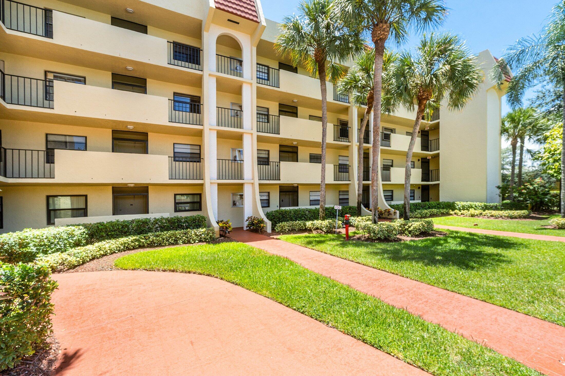 23395 Carolwood Lane, Unit 207 Boca Raton, FL 33428 - Photo 37 of 39 a view of a building next to a yard