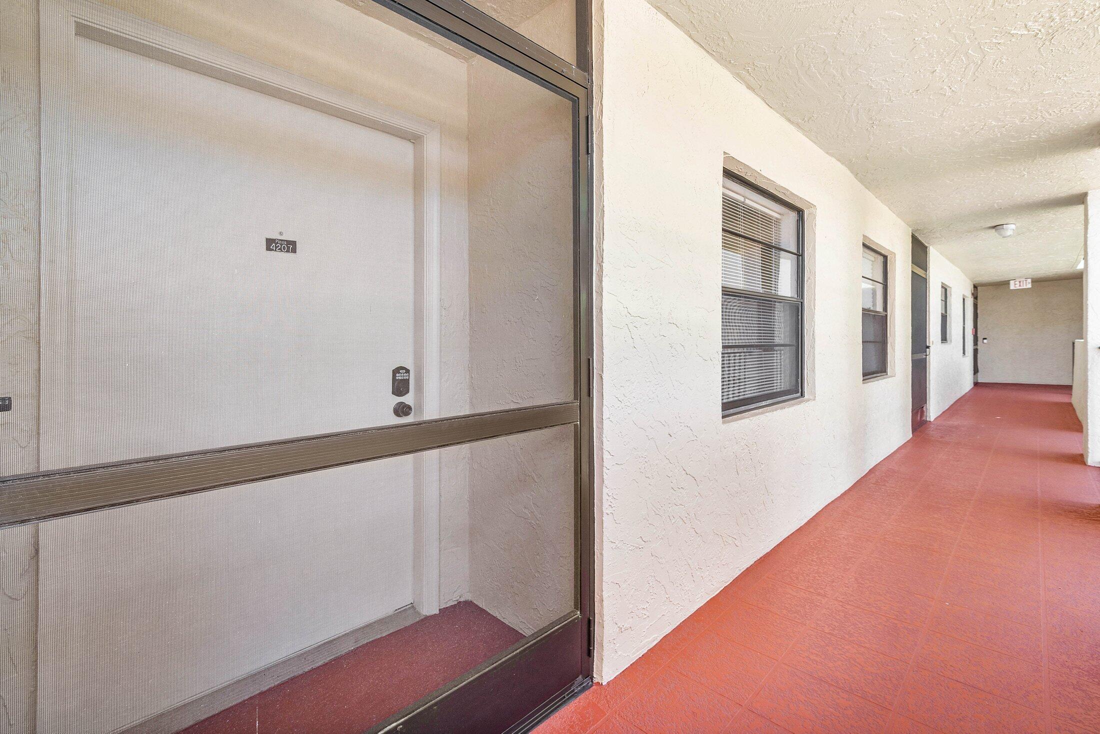 23395 Carolwood Lane, Unit 207 Boca Raton, FL 33428 - Photo 38 of 39 a view of a hallway with wooden floor and staircase