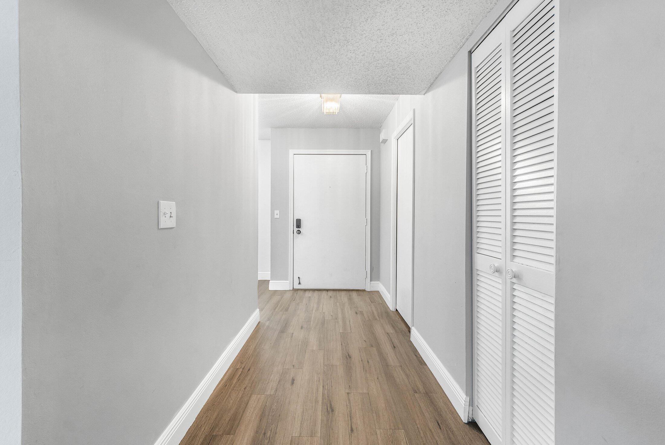 23395 Carolwood Lane, Unit 207 Boca Raton, FL 33428 - Photo 6 of 39 a view of a hallway with wooden floor
