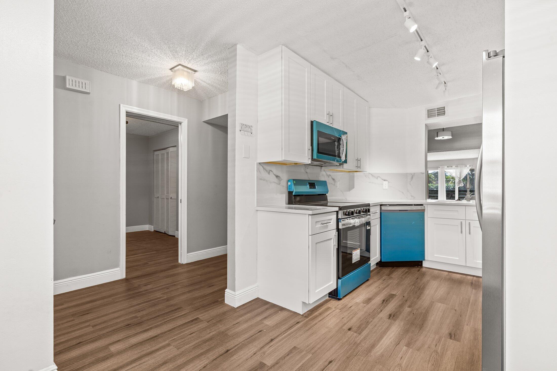 23395 Carolwood Lane, Unit 207 Boca Raton, FL 33428 - Photo 8 of 39 a kitchen with a refrigerator and a stove top oven