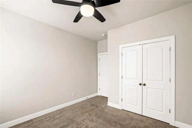 an empty room with a ceiling fan and wooden floor
