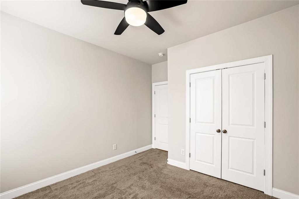 639 Tigers Eye Terrace Kennesaw, GA 30144 - Photo 14 of 36 an empty room with a ceiling fan and wooden floor