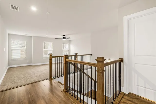 a view of a hallway with wooden floor and windows