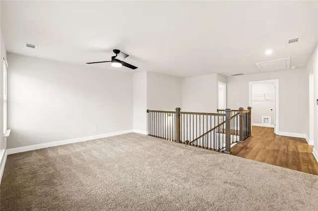 a view of a livingroom with wooden floor and a ceiling fan