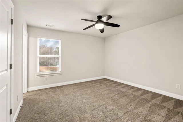 an empty room with a window and a fan