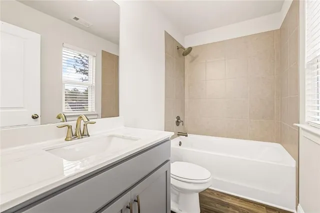 a bathroom with a sink a toilet a mirror a bathtub and shower