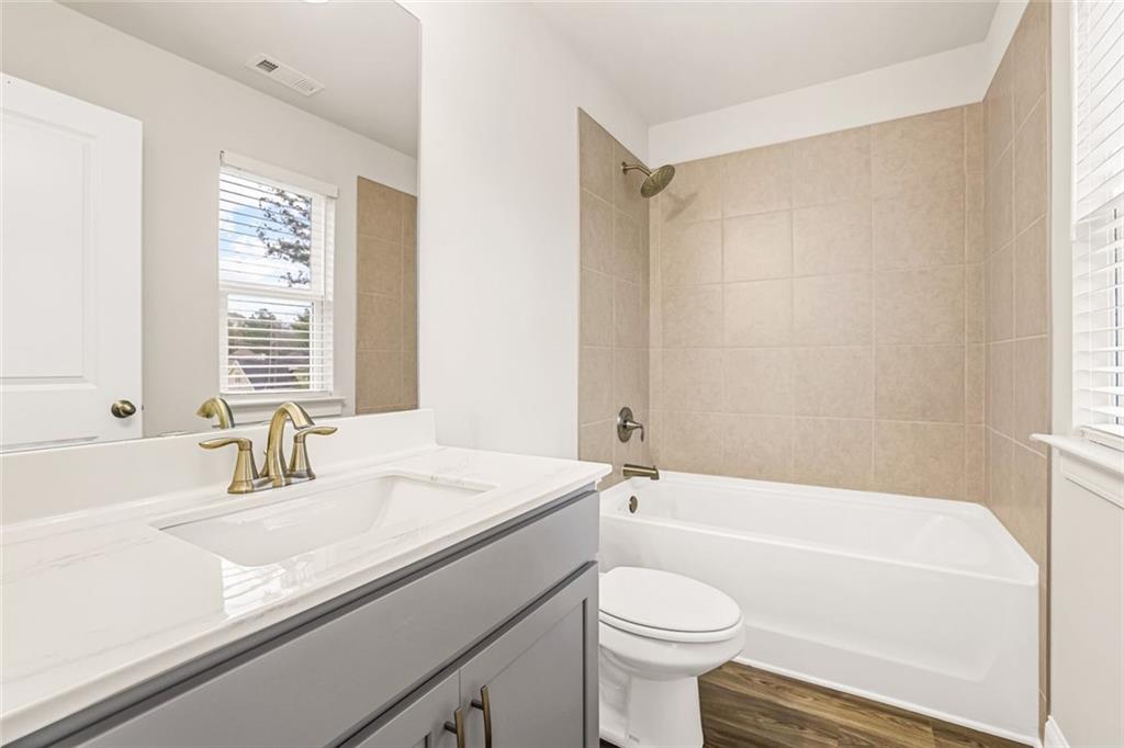 639 Tigers Eye Terrace Kennesaw, GA 30144 - Photo 26 of 36 a bathroom with a sink a toilet a mirror a bathtub and shower