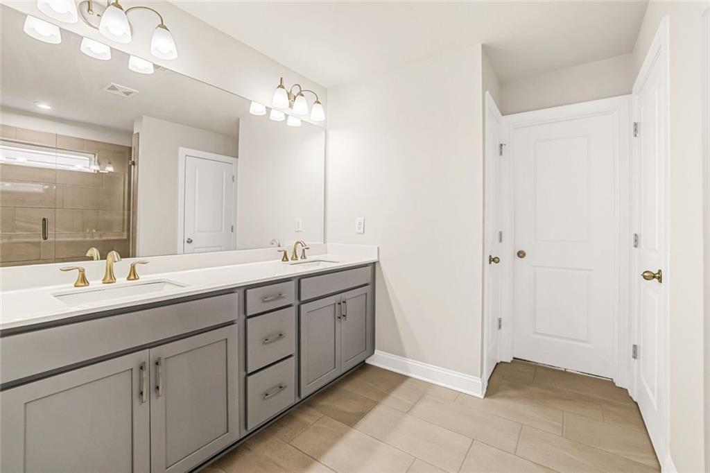 639 Tigers Eye Terrace Kennesaw, GA 30144 - Photo 31 of 36 a bathroom with a double vanity sink and a mirror