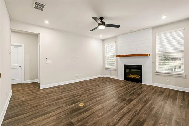 a view of empty room with wooden floor and fireplace