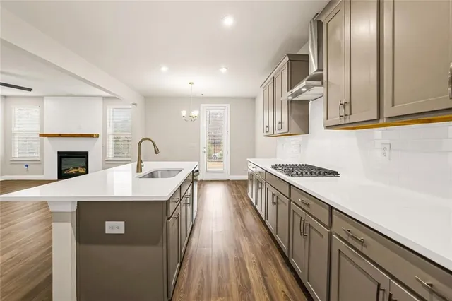 a kitchen with stainless steel appliances granite countertop a sink a stove and a refrigerator