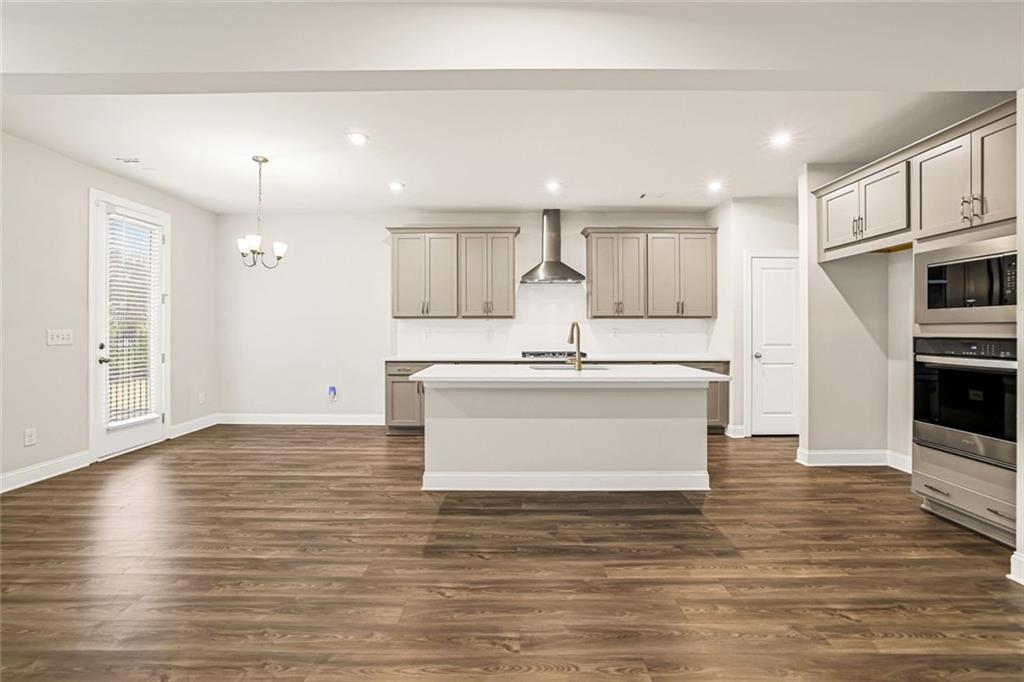 639 Tigers Eye Terrace Kennesaw, GA 30144 - Photo 10 of 36 a view living room with stainless steel appliances kitchen island wooden floor and window